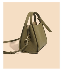 Detail view of olive green pebbled leather bucket bag with elegant gold-tone hardware