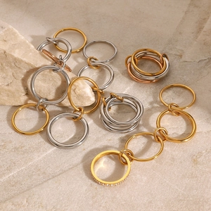 Artistic layout of gold, silver, and rose gold stainless steel rings on stone background