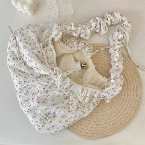 Detailed view of floral bag with lace trim, ruffled strap, and cherry print pattern