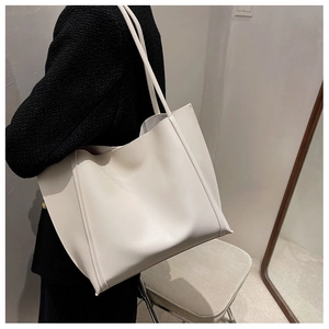 Minimalist ivory tote bag shown on shoulder for a stylish daily lifestyle look