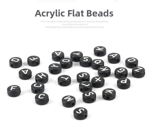Macro shot of 4x7mm black acrylic flat letter beads with white alphabet print for DIY