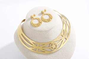 Detailed view of gold metal choker and star earring set on a beige display stand