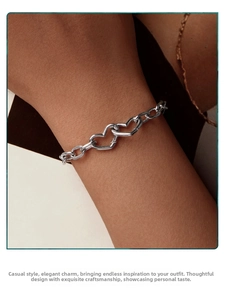 Detail shot of s925 sterling silver interlocking heart chain bracelet on woman's wrist