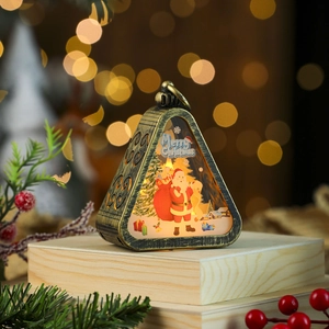 Detail of vintage bronze Christmas lantern featuring Santa print and warm LED light