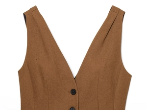 Detailed close-up of dark brown linen vest with V-neckline and textured button closure
