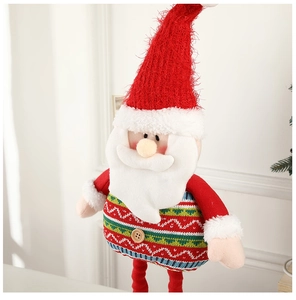 Detail of Santa plush toy with long white beard, red pointed hat, and knitted sweater