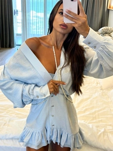Detail of light blue V-neck dress with ruffle hem and layered pearl waist necklace decoration