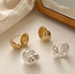 Macro shot of minimalist S925 sterling silver ball hoop earrings in gold and silver