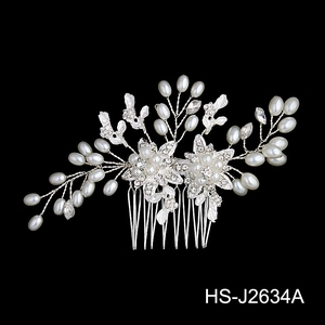 Detailed view of bridal hair comb with pearls, crystals, and silver floral patterns