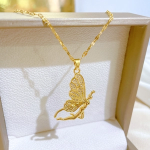Elegant gold butterfly necklace with crystal wings on beige jewelry box with silk