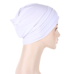 Detail view of white pleated turban cap fabric texture and side design on model