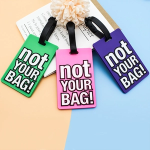 Three PVC luggage tags in green, pink, and purple with 'not YOUR BAG!' text for travel bags