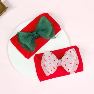 Close-up of red nylon baby headbands with double-layered green and heart mesh bows