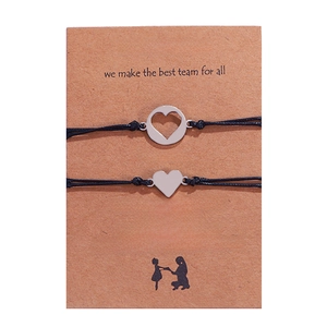Detail of mother and daughter heart charm bracelets on brown kraft paper card