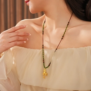 Detail of vintage tiger eye horse pendant necklace with gold accents and colorful beads