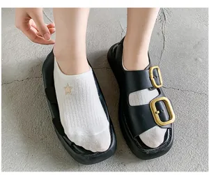 Detail of soft flexible sole on black double-buckle sandals with white cotton socks