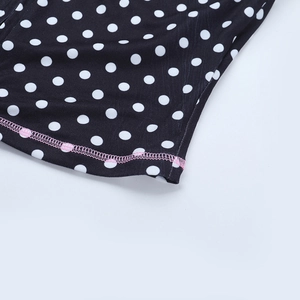 Detail of pink contrast stitching on polka dot fabric showing professional seam finish