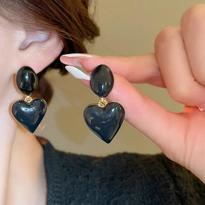Detailed view of vintage oval heart earrings with black drip oil finish and golden plating