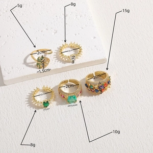 Set of 14K gold plated rings featuring geometric zircons and emerald stones on stone props