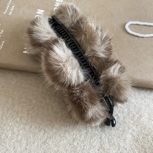 Détail d'une pince à cheveux en peluche marron avec dents en acrylique et fourrure douce