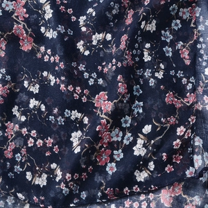 Detailed texture of cotton linen scarf featuring elegant floral patterns and soft folds