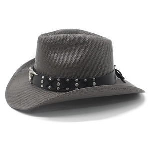 Detail of dark gray straw cowboy hat featuring metal bull skull ornament and studs
