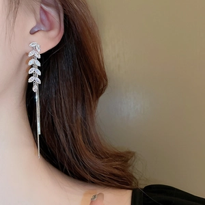 Macro shot of silver zircon wheat ear earrings with elegant long tassel chain fringe