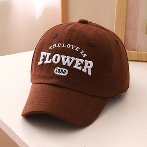 Gros plan d'une casquette en coton marron avec broderie 3D blanche et texture du tissu