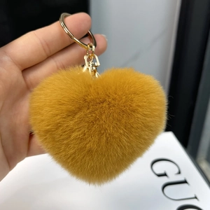 Detail of brown heart-shaped faux rabbit fur keychain with golden metal ring and hook