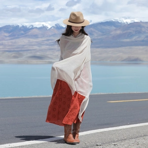 Close-up of ethnic style cream white shawl and orange floral maxi dress with lake view