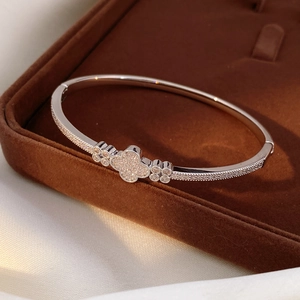 Macro detail of silver clover bracelet with sparkling white zircon pavé setting