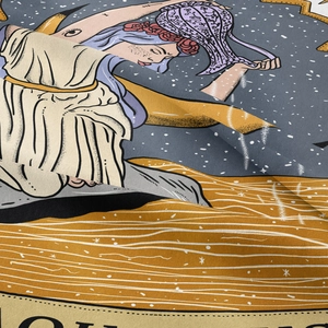 Detailed macro view of woven fabric texture and Aquarius zodiac print on tapestry