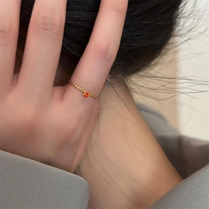 Minimalist 18k gold plated stainless steel ring with orange gemstone on model's hand