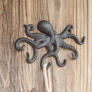 Rustikaler Wandhaken aus Gusseisen im Oktopus-Design auf strukturiertem Holzhintergrund