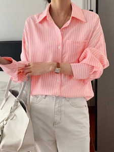 Close-up detail of pink and white striped shirt with button collar and loose casual cuffs