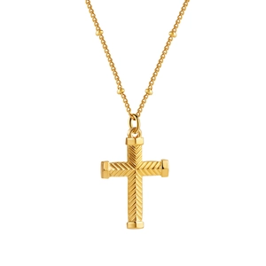 Close-up of golden cross pendant with herringbone texture and bead satellite chain