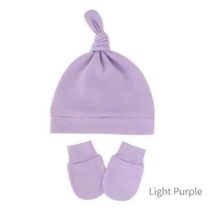 Detail view of light purple knitted baby hat with top knot and matching mittens set