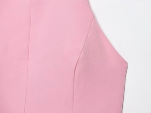 Macro shot of pink woven fabric texture and stitching details for women's halter dress