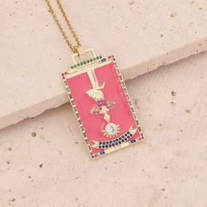 Golden tarot pendant necklace with pink enamel and multicolor gemstones on stone surface