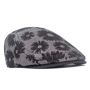 Close-up of jacquard daisy pattern on grey denim flat cap with twill texture detail