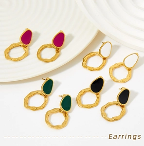 Close-up of vintage enamel stud earrings with gold hammered irregular metal rings