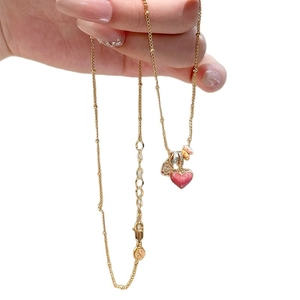 Gold beaded chain necklace with pink enamel heart pendant and textured square charm