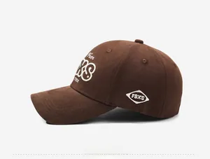 Detail view of the embroidered letters and structured fabric of the brown baseball cap
