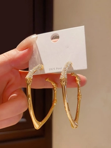 Detailed view of S925 silver post gold bamboo hoop earrings with sparkling crystal pavé