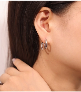 Close-up of minimalist silver double-layer curved geometric stud earrings on model