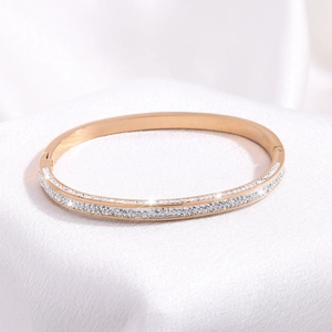 Detail shot of rose gold titanium bangle featuring double row micro-paved white zircons