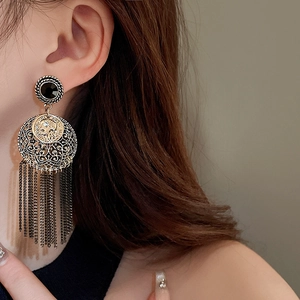 Bohemian tassel earrings with vintage portrait coin and hanging metal fringe on model