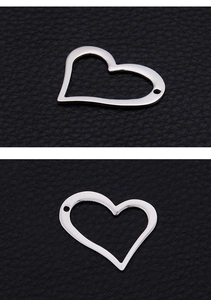 Detailed view of silver heart-shaped hollow connector on black leather texture