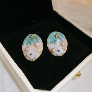 Macro detail of vintage oil painting style earrings with pearls and stars in a box