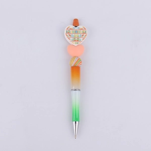 Detail of DIY beadable pen with heart decor featuring a colorful book pattern and gradient body